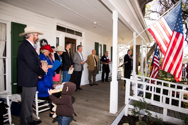 Ceremony begins with speeches from the porch of the Nat Hart Davis Cottage.